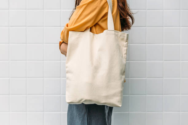 Woman is holding bag canvas fabric for mockup blank template.